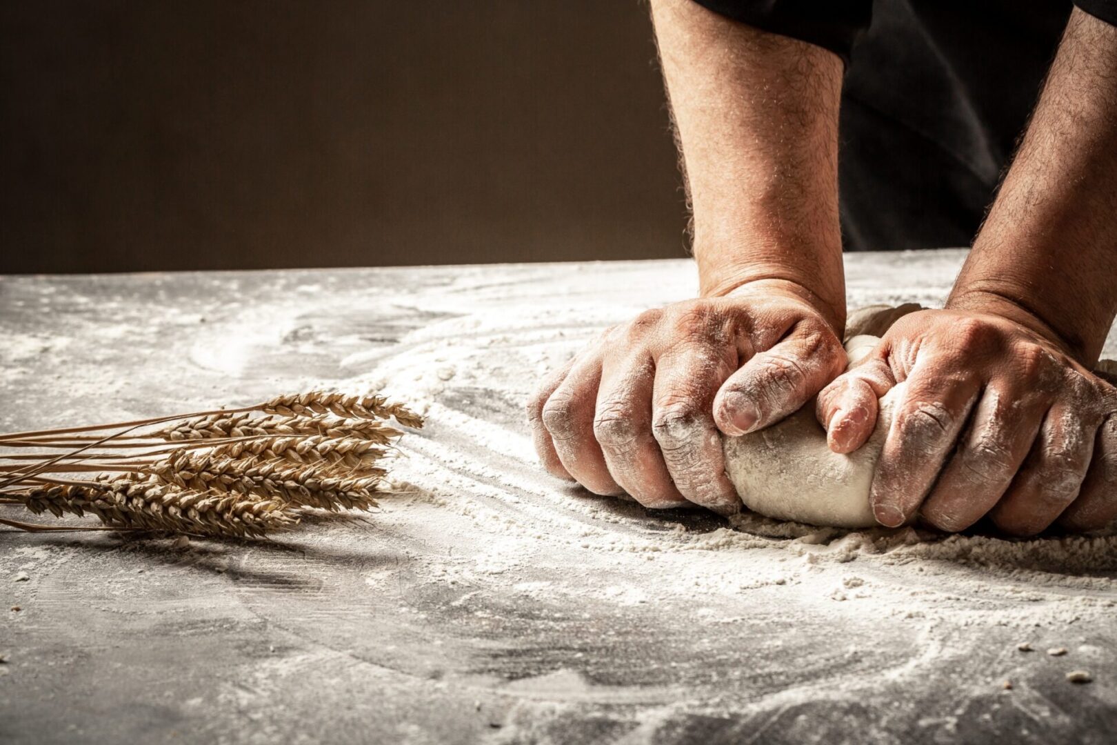 baker's hands kneading bread dough illustrating a metaphor to work with
