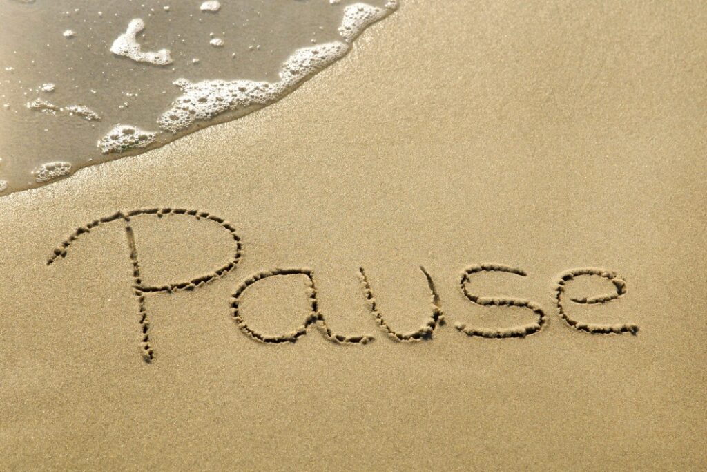 image of PAUSE written in sand to illustrate the idea of taking one short pause