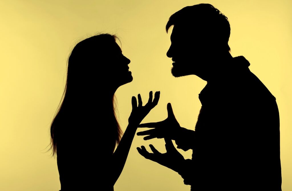 silhouetted couple arguing, representing the need to use your words and choose your words carefully