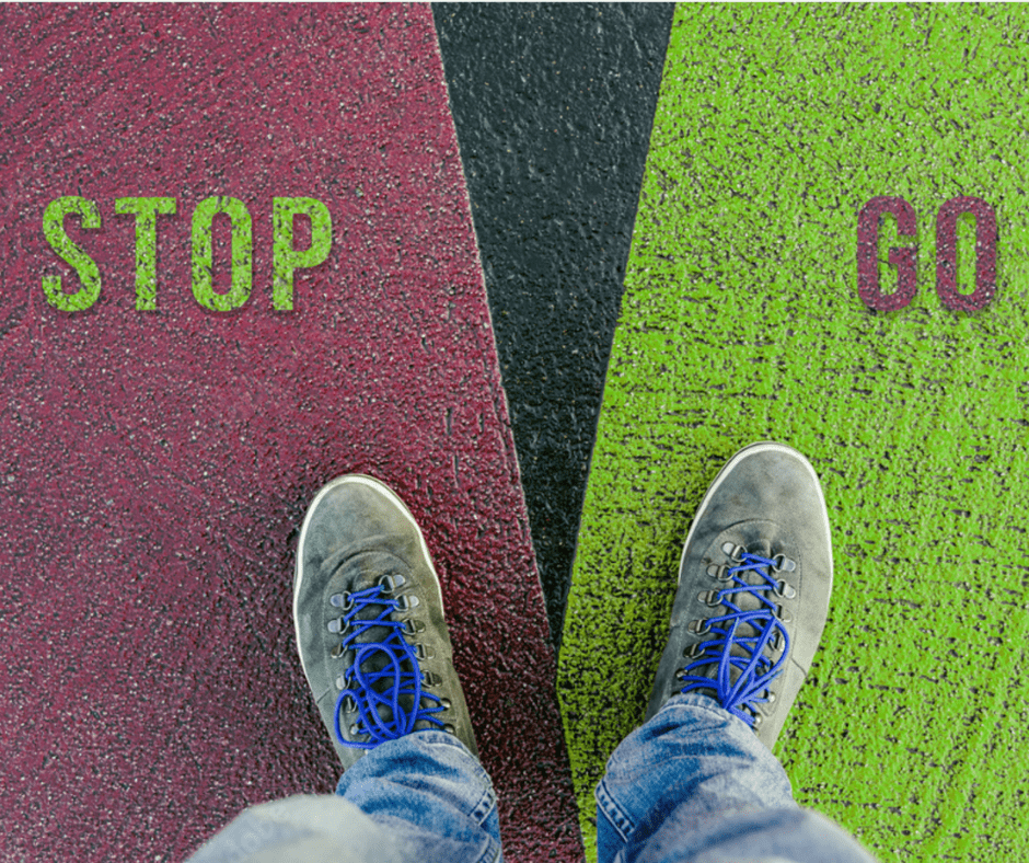 Feet standing on a mat that offers two choices, stop and go, illustrating the idea of making little choices that can lead to big changes.