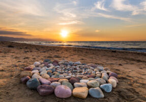 Stones Spiritual Ritual Ceremonial A circle of rocks on the beach at sunset.